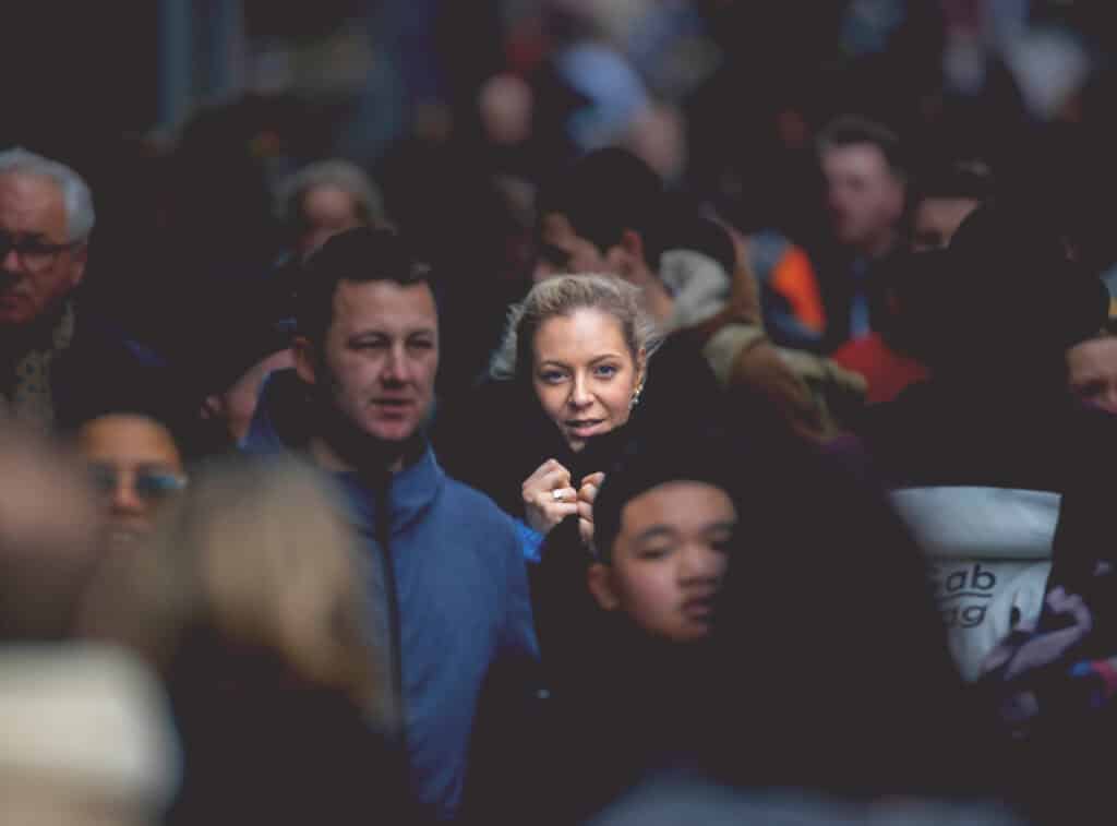 Building trust in a complex world: A woman stands out in a crowd, symbolizing focus, individuality, and the importance of security in fostering relationships.